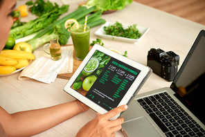 Woman reading green smoothie formula on dogotal tablet