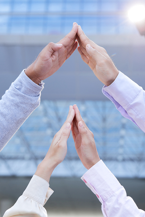 Business people making roof gesture with their hands as a symbol of safety and hospitality