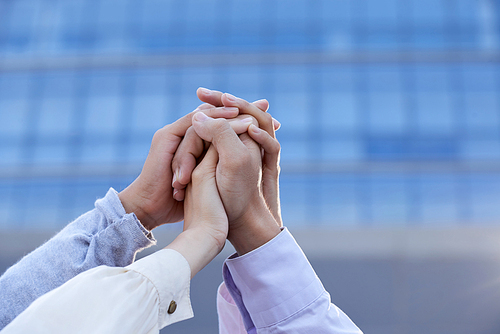 Business coworkers clasping their hands together to show unity