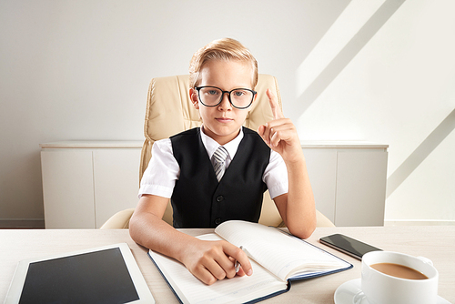 Smart kid in glasses having an idea