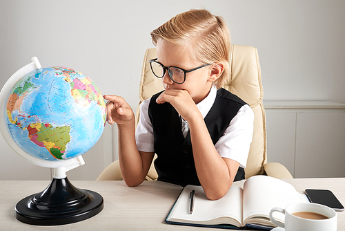 Boy examining globe to explore the world