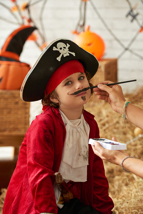 Little boy having his face painted for Halloween celebration
