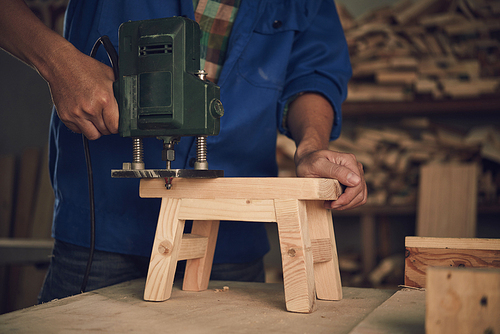 Cropped image of joiner making little wooden stool
