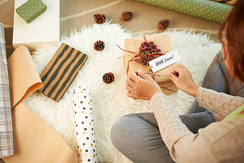 Hands of woman wrapping a gift, view from above