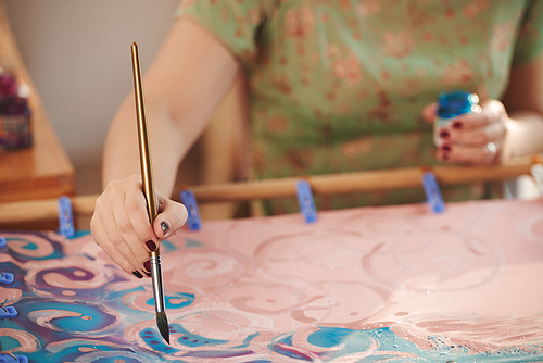 Close-up image of creative woman painting with brush