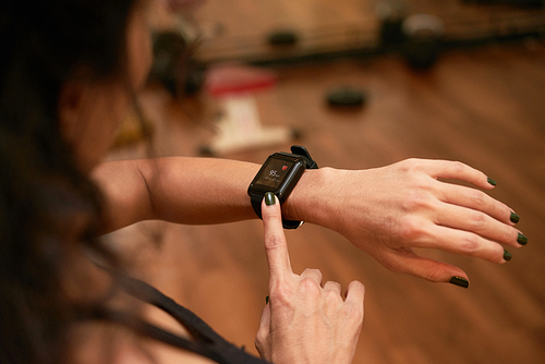 Hands of woman checking pulse in application on her smart watch