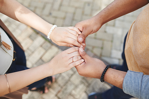 Man holding hands of his fiance, view from above