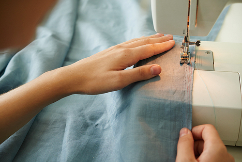 Close-up image of fashion designer sewing clothes