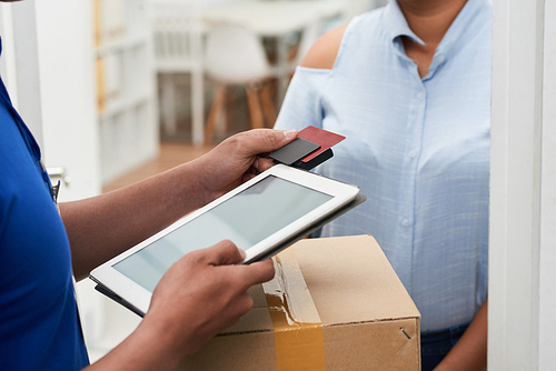 Delivery man using card reader to accept payment for package delivery