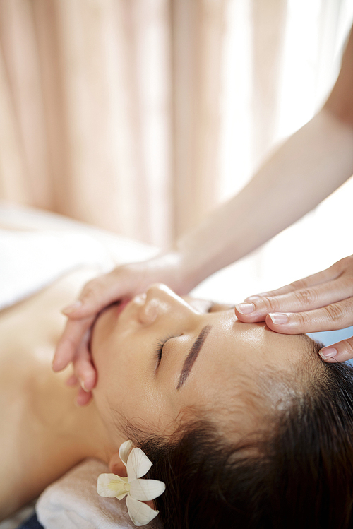 Specialist doing rejuvenating face massage with oils and serum