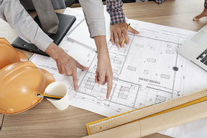 Hands of architects checking measurements of every wall of the house they are working on