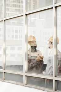 Professional civil engineers standing inside building and discussing work