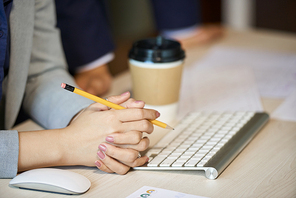 Manicured hands of businesswoman sitting at her desk in office