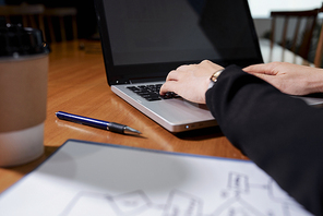 Hands of businesswoman working on laptop and answering e-mails