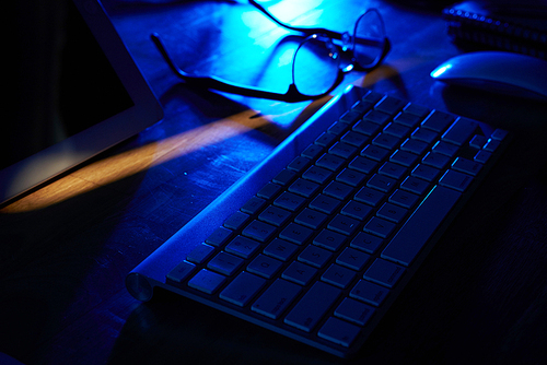 Keyboard and glasses on tablet of programmer in office of IT company