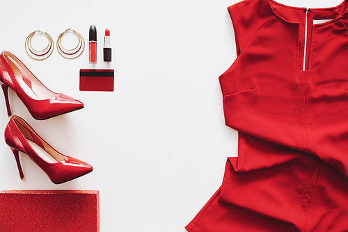 Red dress, heels and cosmetics on white background