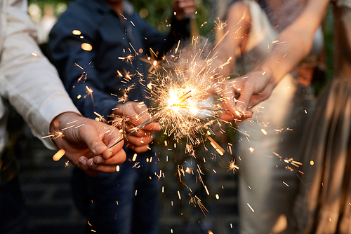 Burning sparklers in hands of party guests