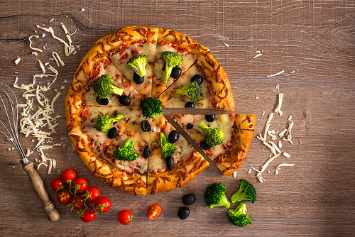 Cut hot delicious pizza with cheese, black olives and broccoli