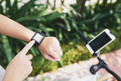 Close-up image of female cyclist using map application on smart watch