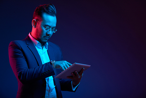 Confident Vietnamese entrepreneur using application in digital tablet
