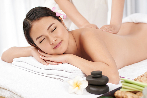 Young Asian woman smiling when getting back massage
