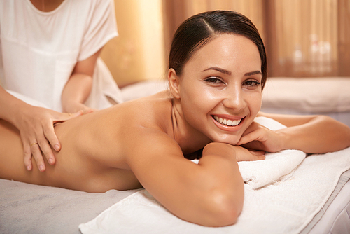 Gorgeous young woman enjoying massage in beauty salon