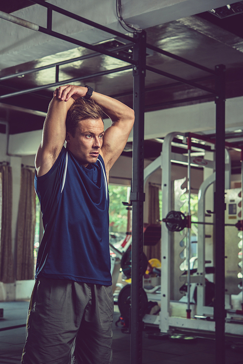 Fit young man stretching arms after working out