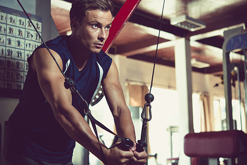 Handsome young fit man training in gym