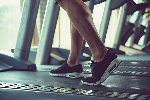 Athlete warming up on threadmill in gym