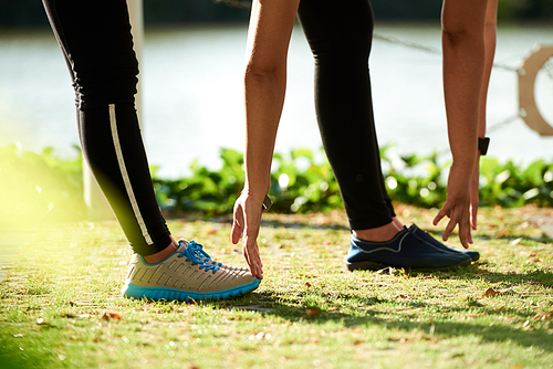 Cropped image of women stretching after jogging outdoors