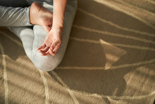 Cropped image of yogi meditating in lotus position. view from above