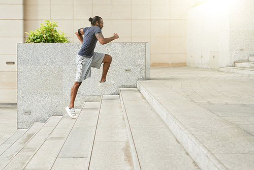 Active sporty Indonesian man running up the stairs