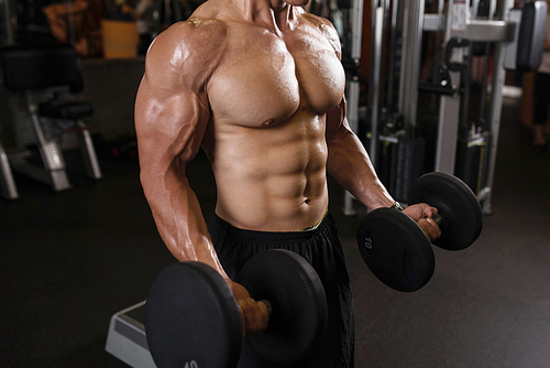 Shirtless athlete doing exercises with heavy dumbbells