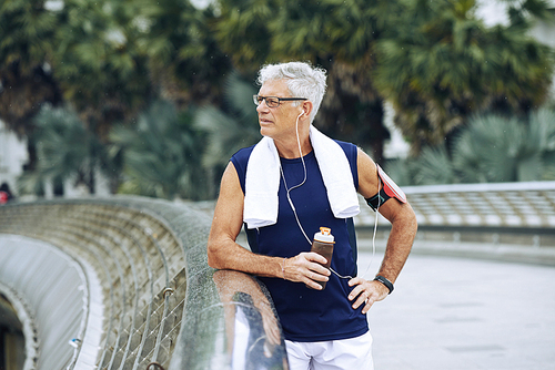 Senior sportsman drinking fresh water after running