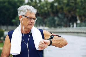 Aged sporty man checking his fitness tracker