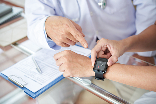 Doctor explaining patient how to use health application on smartwatch