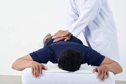 Cropped image of doctor checking spine of young patient