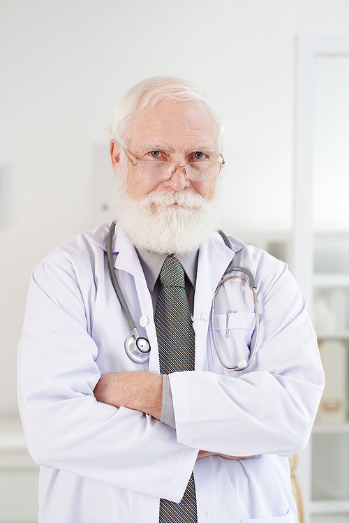 Portrait of confident senior general practitioner standing with his arms crossed