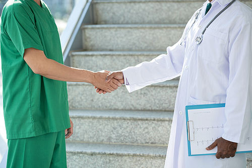 Cropped image of cardiologist and surgeon shaking hands