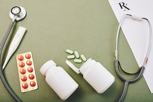 Prescribed pills and tablets on green background