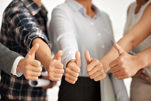 Group of business people showing thumbs-up, selective focus