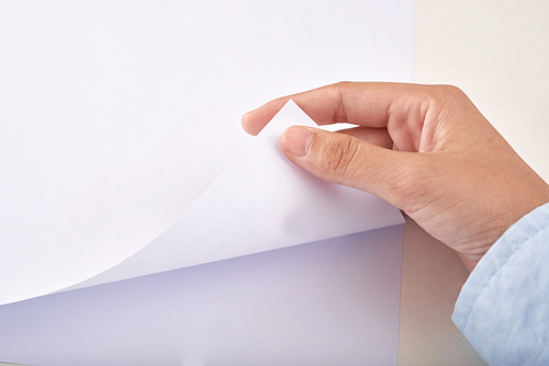 Close-up image of person turning page, view from above