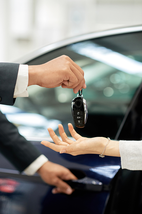 Car dealer giving keys to female customer