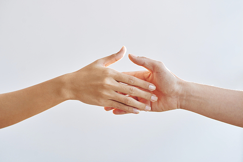 Crop hands of man and woman touching with tenderness on grey background