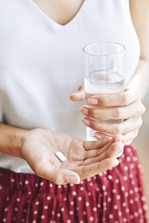 Woman taking painkiller to get rid of migraine