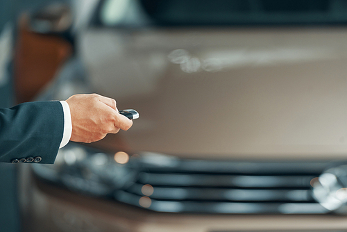 Hand of owner using electronic car key to open door