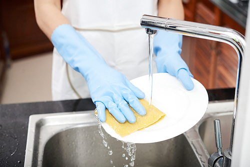 Hands woman woman wearing gloves when washing plate in sink