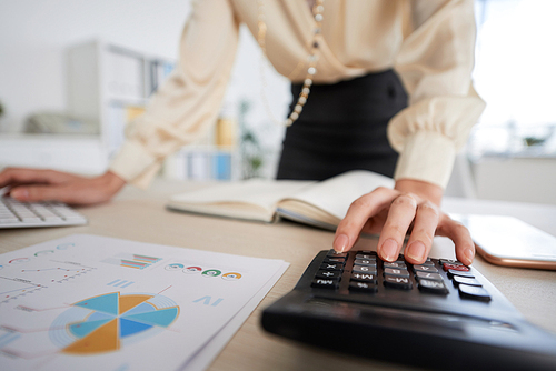 Business lady calculating revenue for financial report, selective focus