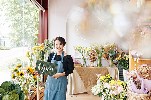 Portrait of young pretty Vietnamese woman opening her first flower shop