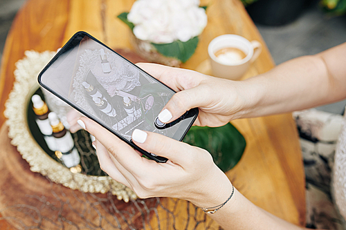 Hands of cosmetics brand owner taking photos of new products and uploading on social media or online shop